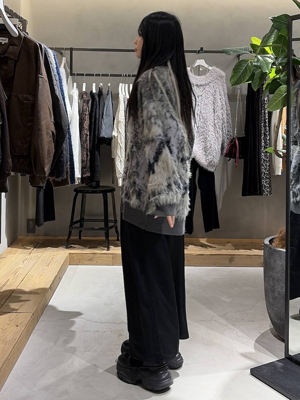 ブラック系のブーツ、グレー系のカーディガン/ボレロ、ブラック系のニット/セーターを着用したレディースの冬コーディネートの2枚目の写真