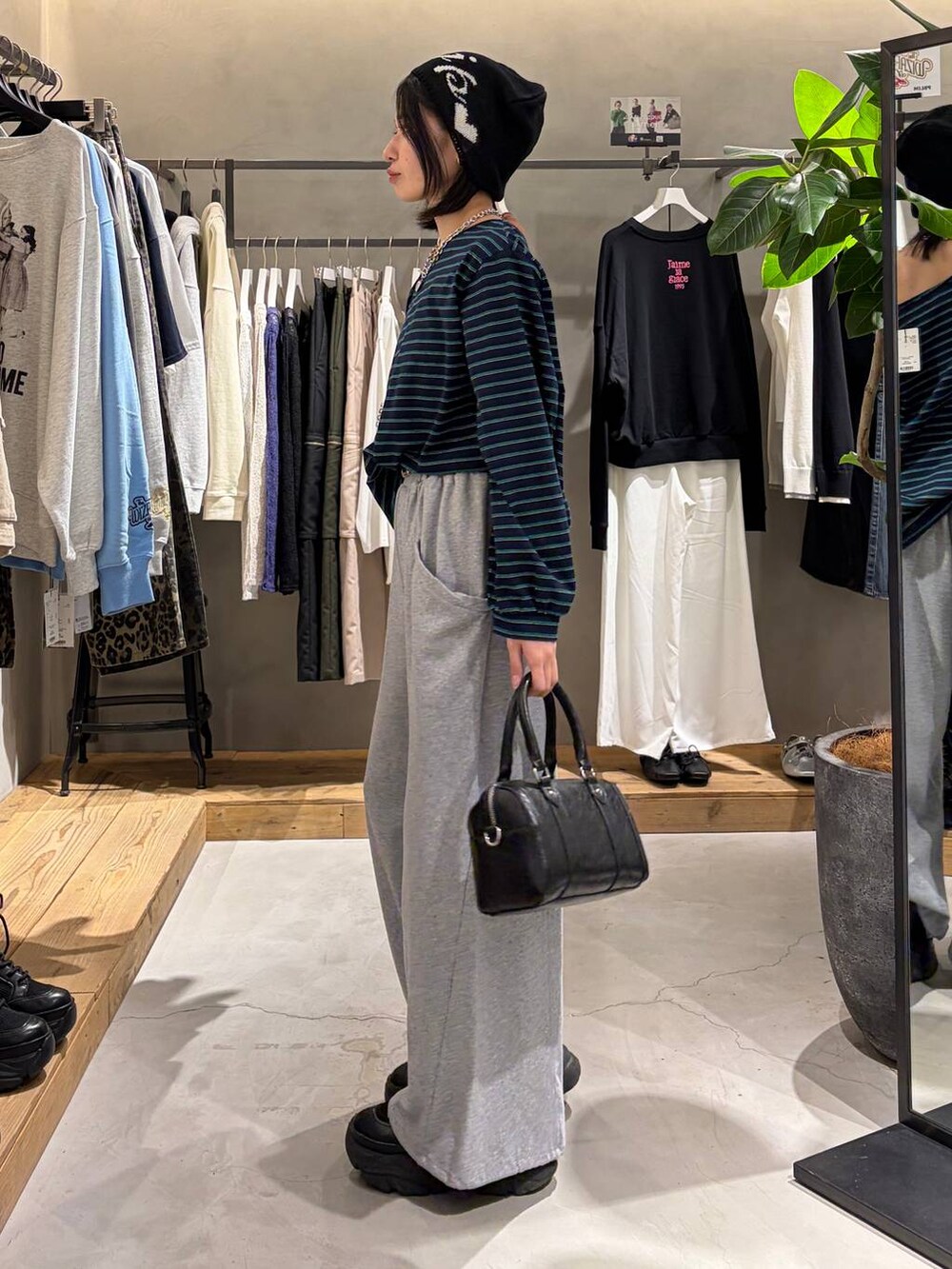 ブラック系のブーツ、ブラック系のボストンバッグ、グレー系のスウェットパンツを着用したレディースの冬コーディネートの2枚目の写真