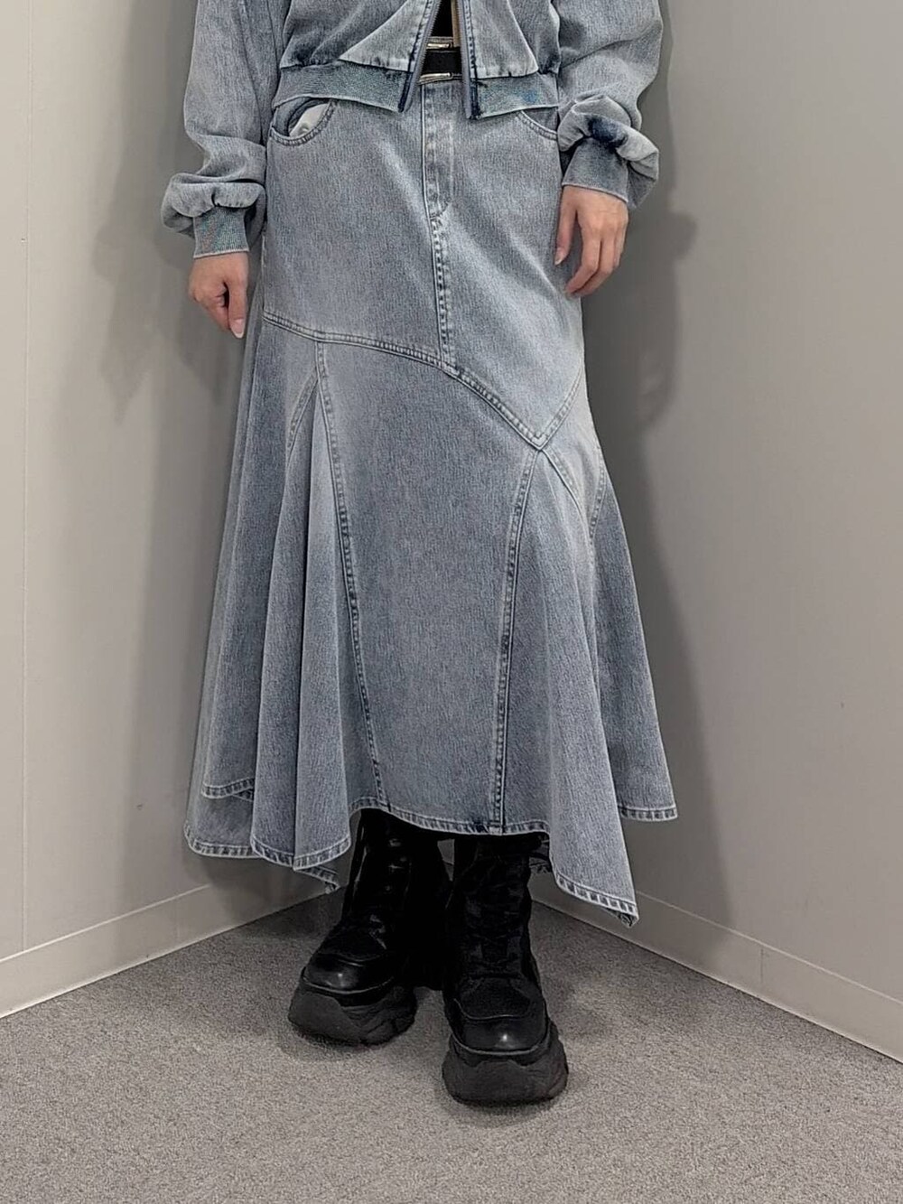 ブラック系のブーツ、ブラック系のニット/セーター、ブルー系のデニムスカートを着用したレディースの冬コーディネートの5枚目の写真