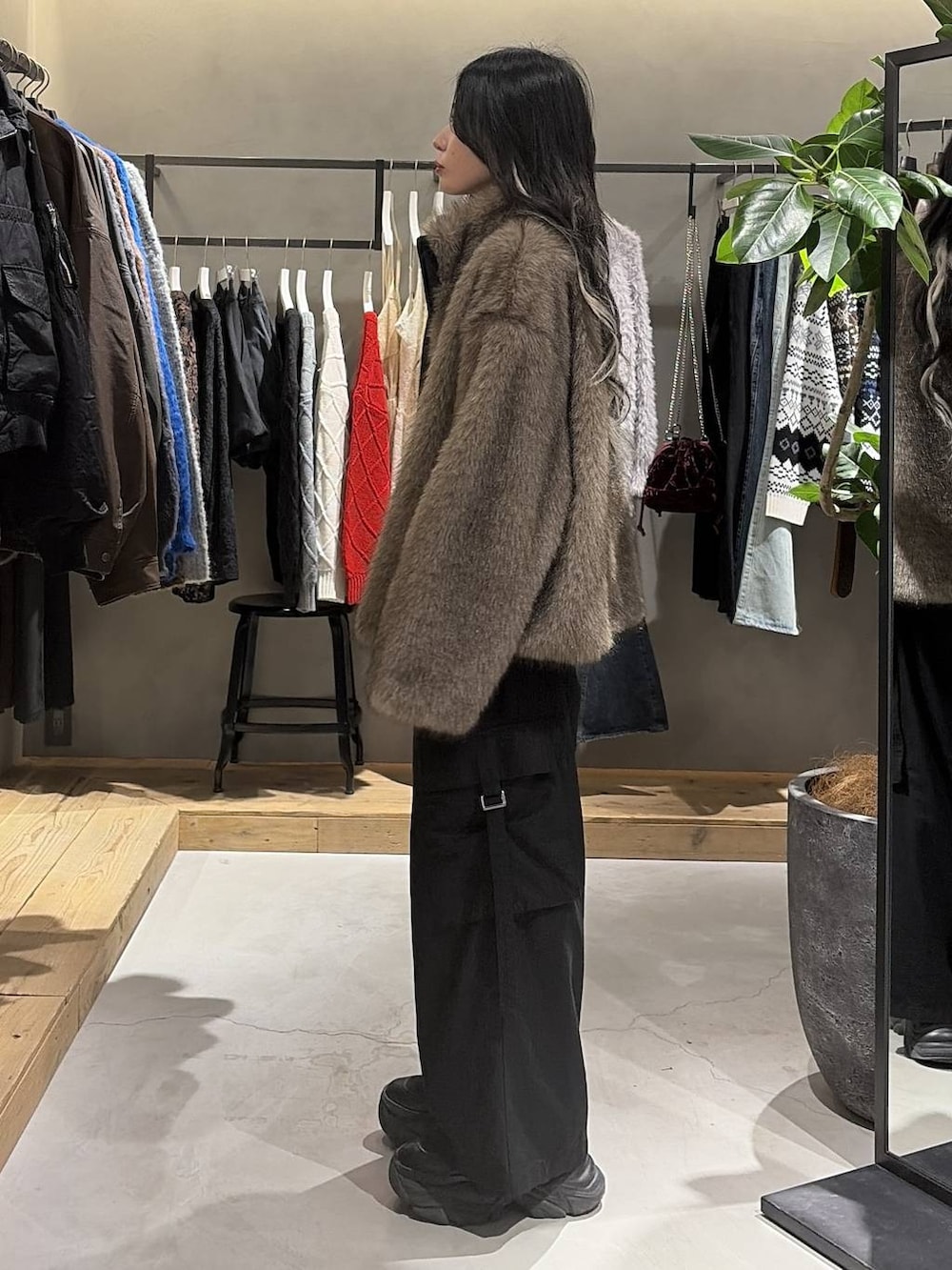 ブラック系のブーツ、ブラック系のスラックス、ブラウン系のブルゾンを着用したレディースの冬コーディネートの2枚目の写真