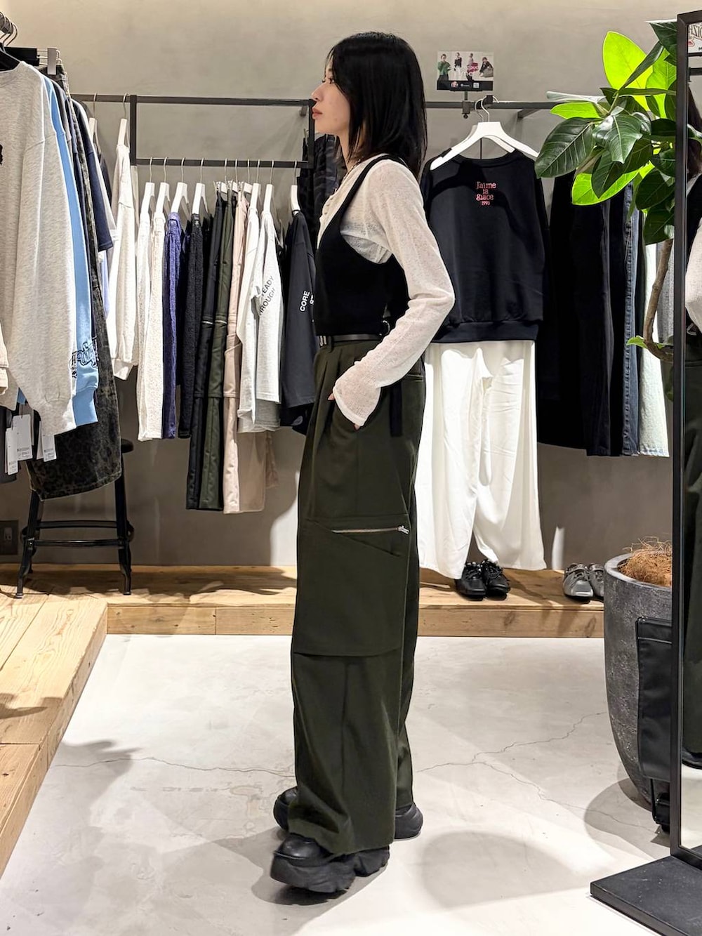 ブラック系のブーツ、グリーン系のスラックス、ホワイト系のTシャツ/カットソーを着用したレディースの春コーディネートの2枚目の写真