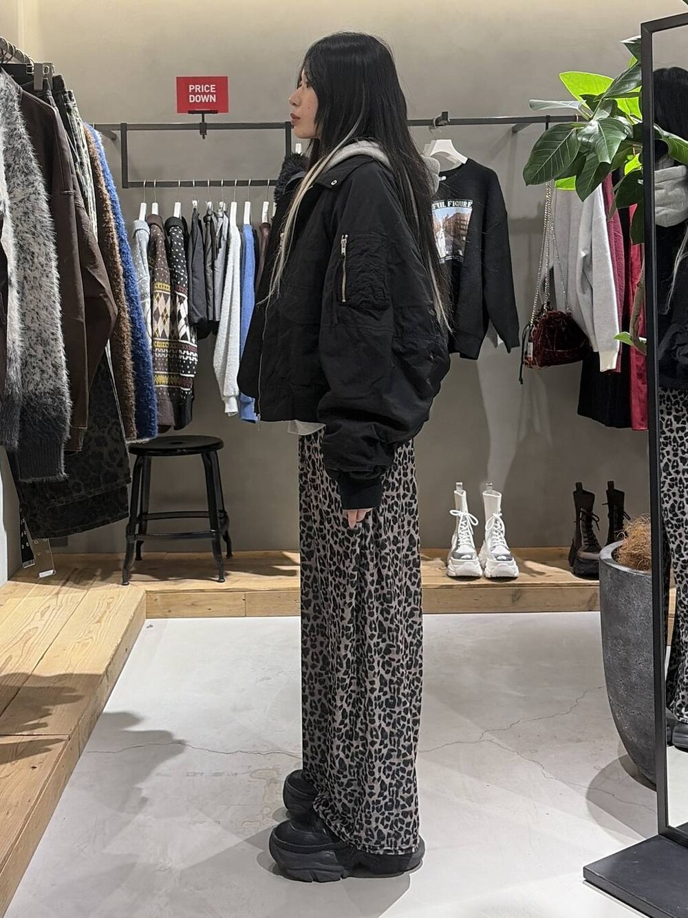 ブラック系のブーツ、グレー系のパーカー、ベージュ系のその他パンツを着用したレディースの冬コーディネートの2枚目の写真