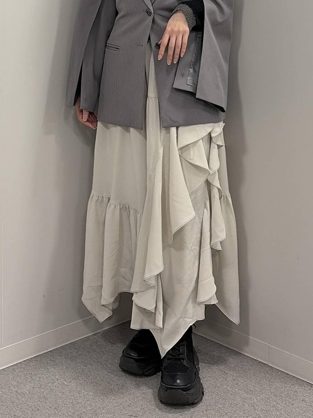 ブラック系のブーツ、ブラック系のニット/セーター、グレー系のテーラードジャケットを着用したレディースの冬コーディネートの5枚目の写真