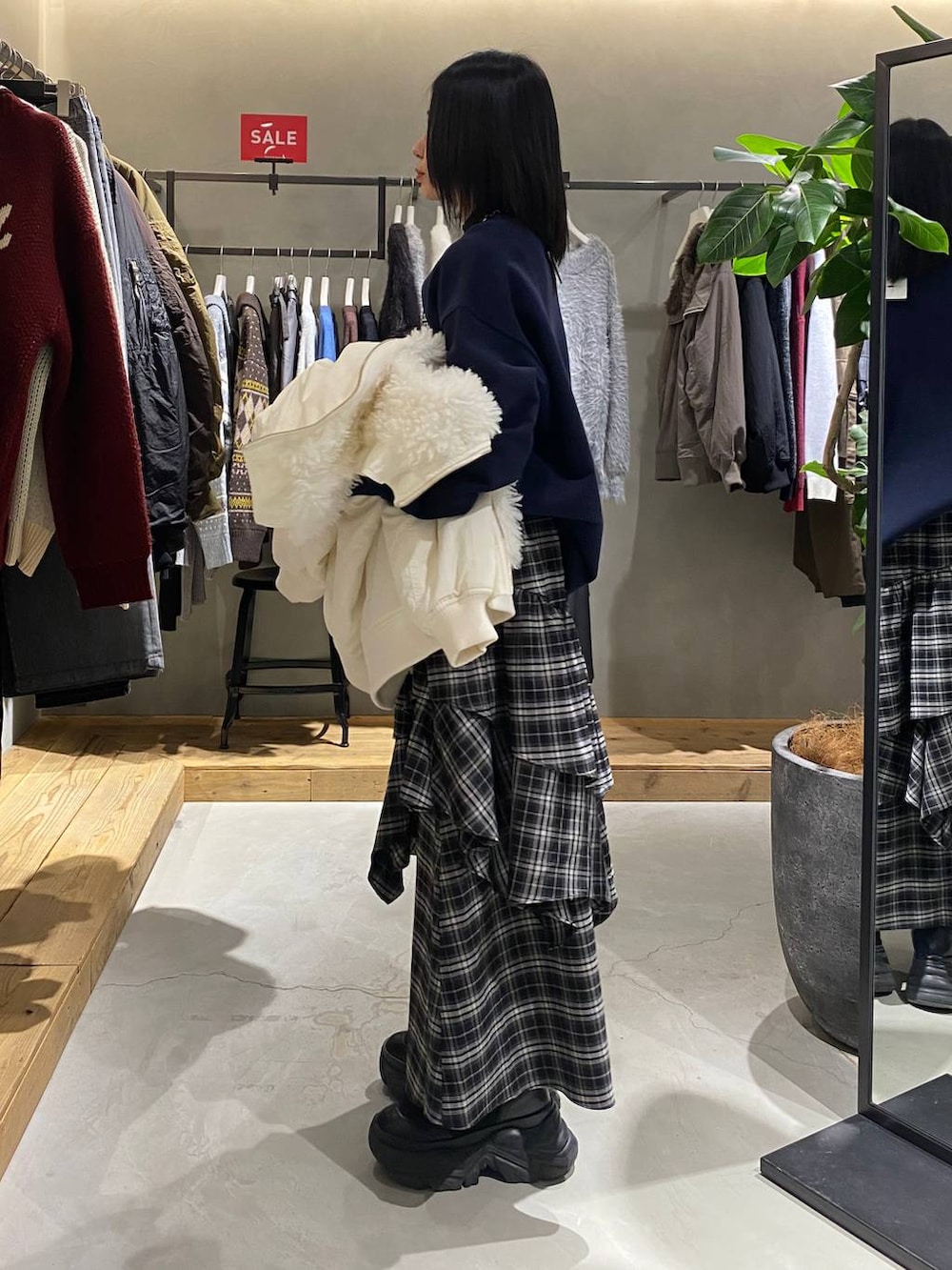 ホワイト系のブルゾン、ホワイト系のスカート、ブルー系のスウェットを着用したレディースの冬コーディネートの2枚目の写真