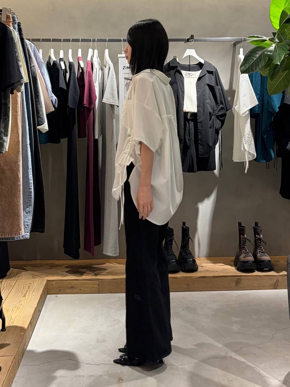 ブラック系のデニムパンツ、ブラック系のサンダル、ホワイト系のシャツ/ブラウスを着用したレディースの春コーディネートの2枚目の写真