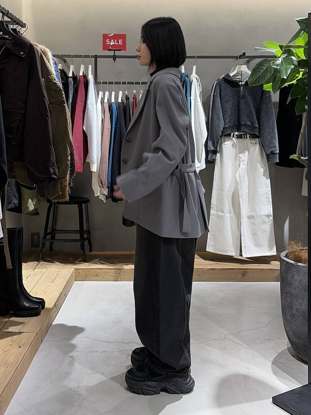 ブラック系のブーツ、ブラック系のニット/セーター、ブラック系のデニムパンツを着用したレディースの冬コーディネートの2枚目の写真