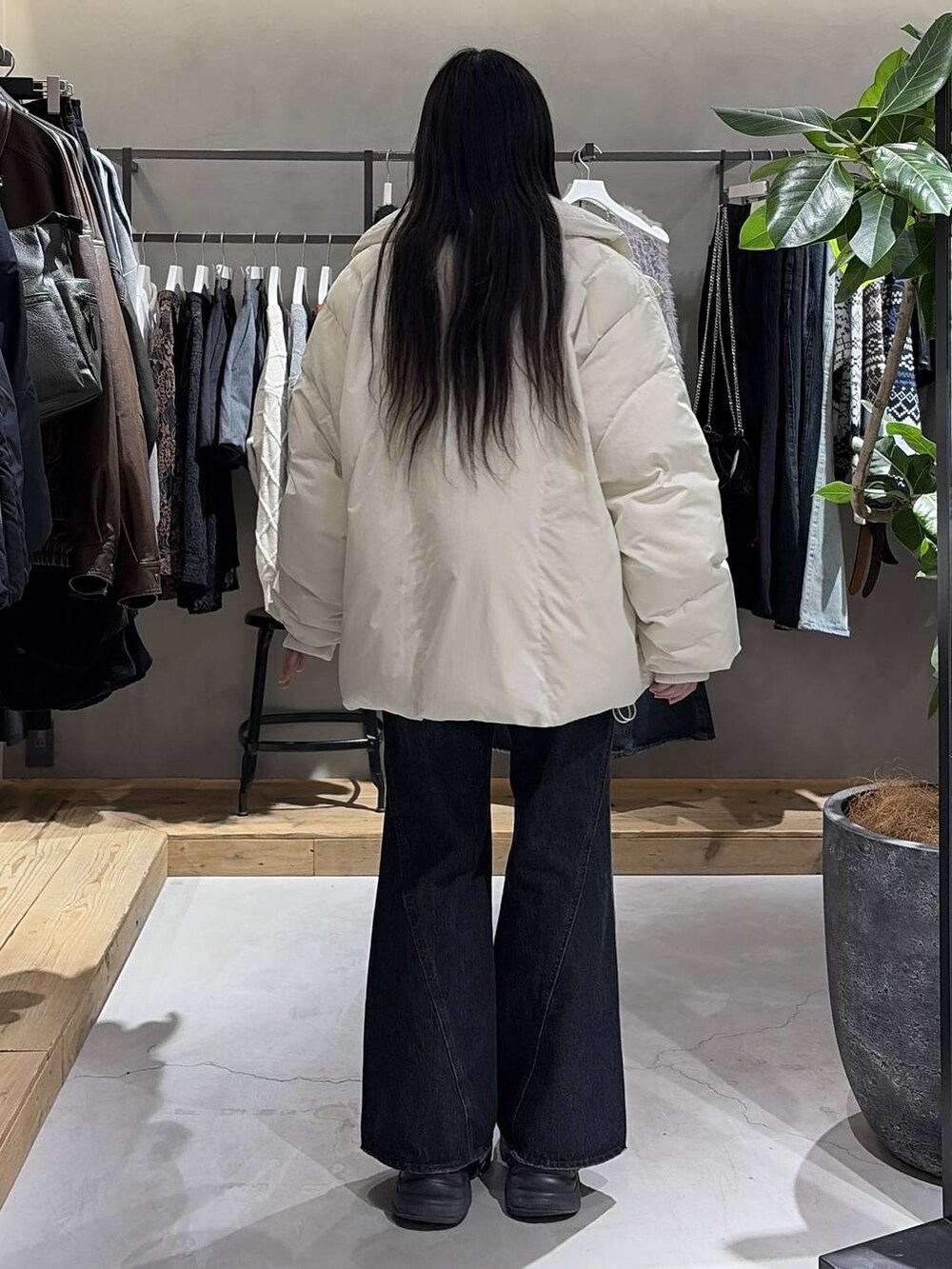 ブラック系のブーツ、ブルー系のデニムパンツ、ホワイト系のブルゾンを着用したレディースの冬コーディネートの3枚目の写真