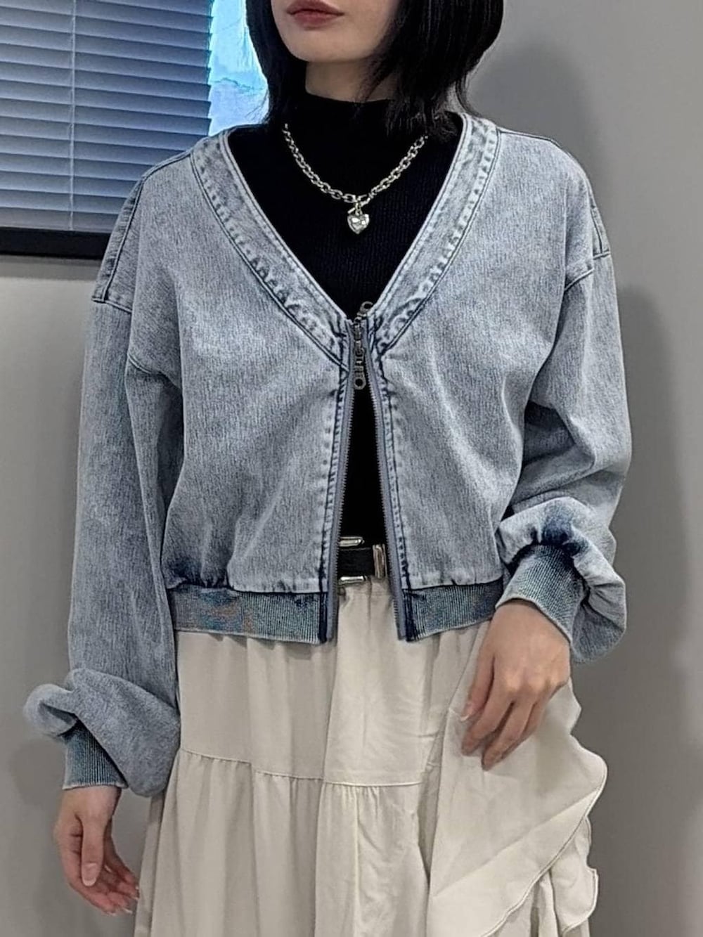 ブラック系のブーツ、ブラック系のニット/セーター、ベージュ系のスカートを着用したレディースの冬コーディネートの4枚目の写真