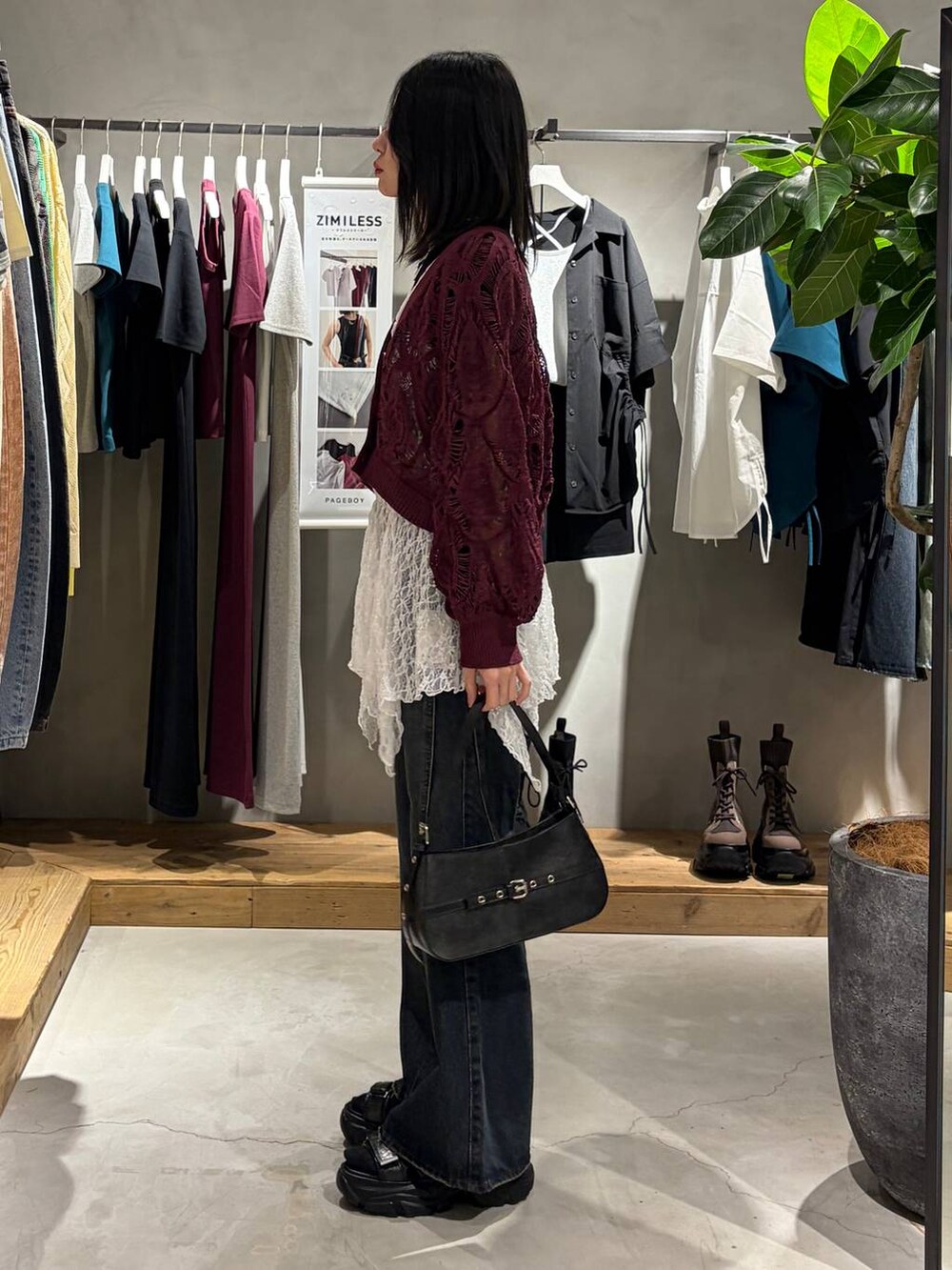 パープル系のカーディガン/ボレロ、ブルー系のデニムパンツ、ブラック系のハンドバッグを着用したレディースの春コーディネートの2枚目の写真