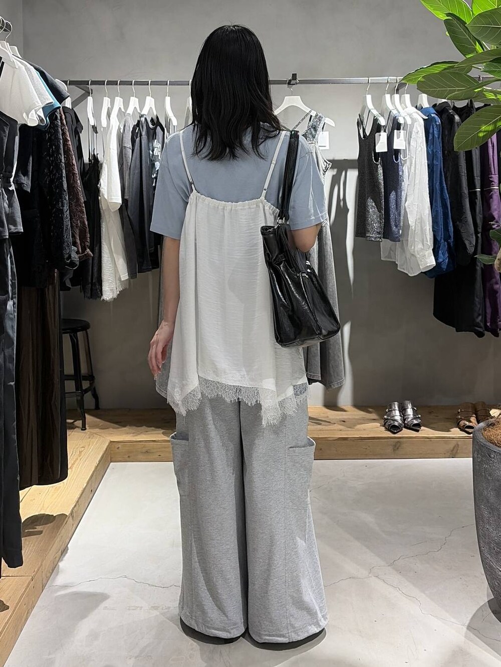 ブルー系のTシャツ/カットソー、ブラック系のサンダル、ホワイト系のキャミソールを着用したレディースの夏コーディネートの3枚目の写真