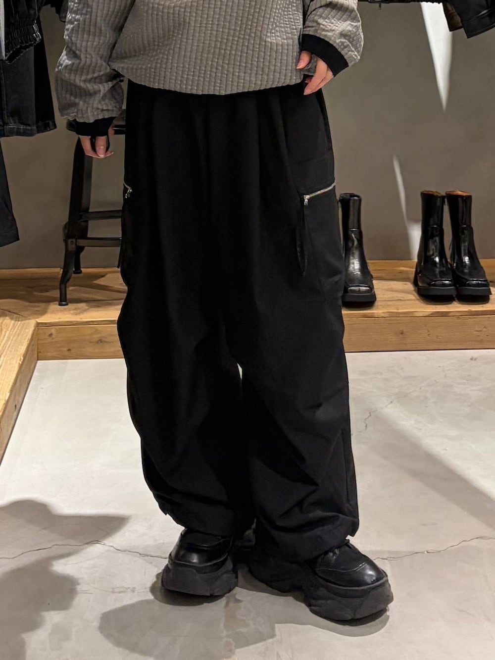ブラック系のカーゴパンツ、グレー系のポロシャツ、ブラック系のブーツを着用したレディースの秋コーディネートの5枚目の写真