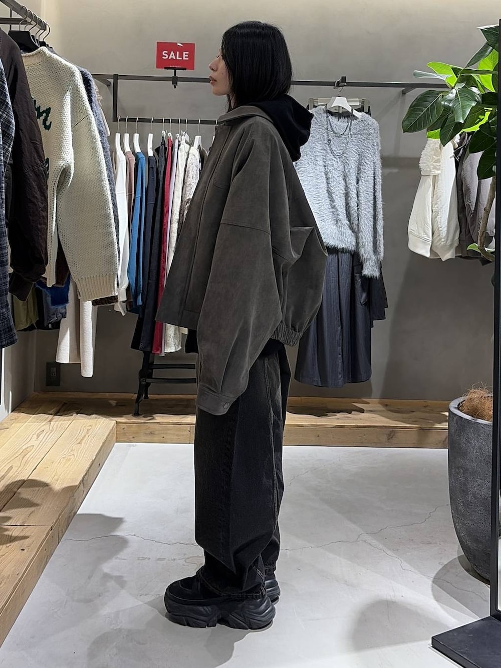 ブラック系のブーツ、ブラック系のデニムパンツ、ホワイト系のTシャツ/カットソーを着用したレディースの冬コーディネートの2枚目の写真