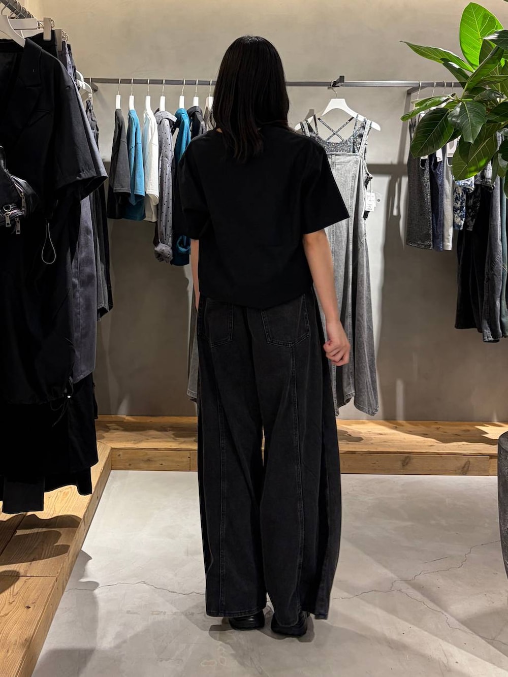ブラック系のデニムパンツ、ブラック系のTシャツ/カットソー、ブラック系のサンダルを着用したレディースの夏コーディネートの3枚目の写真