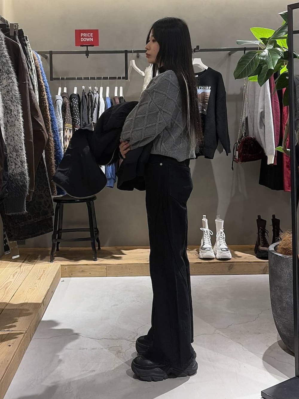 ブラック系のブーツ、ブラック系のデニムパンツ、ブラック系のブルゾンを着用したレディースの冬コーディネートの2枚目の写真