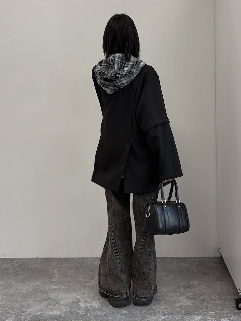 ブラック系のブーツ、ブラック系のボストンバッグ、ブラック系のテーラードジャケットを着用したレディースの春コーディネートの3枚目の写真