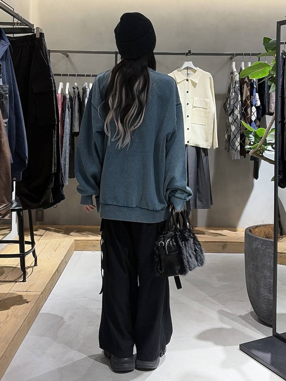 ブラック系のブーツ、ブラック系のスラックス、グリーン系のスウェットを着用したレディースの秋コーディネートの3枚目の写真