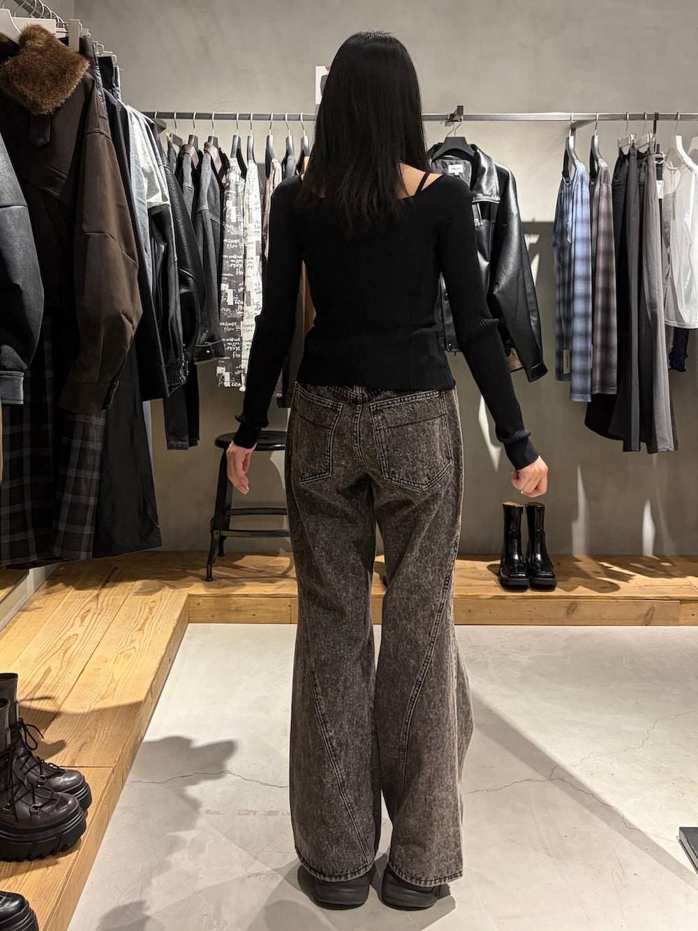 ブラック系のニット/セーター、ブラック系のデニムパンツ、シルバー系のネックレスを着用したレディースの秋コーディネートの3枚目の写真