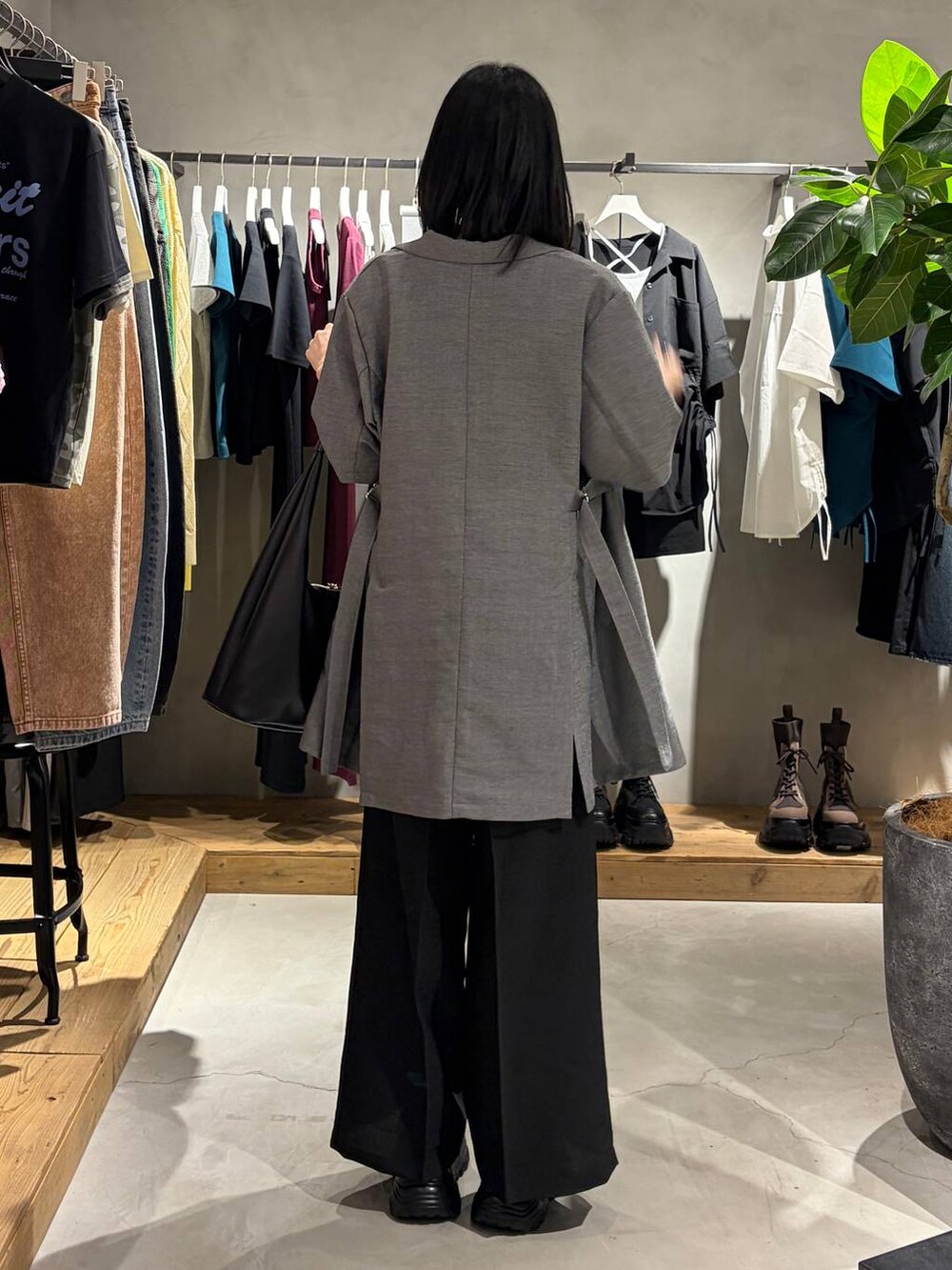 ブラック系のトートバッグ、ブラック系のサンダル、ブラック系のスラックスを着用したレディースの春コーディネートの3枚目の写真