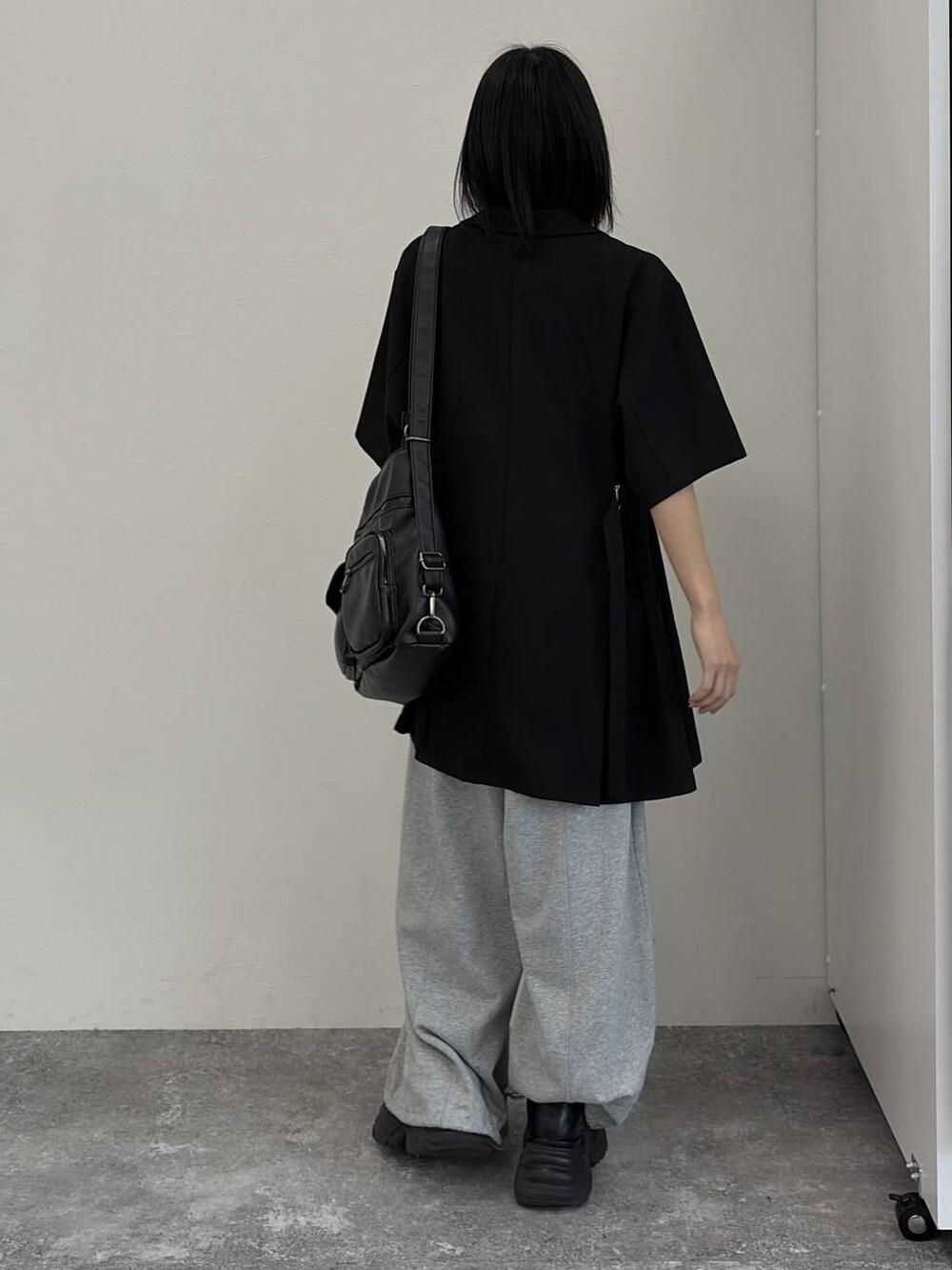 グレー系のスウェットパンツ、ブラック系のショルダーバッグ、ブラック系のテーラードジャケットを着用したレディースの春コーディネートの3枚目の写真