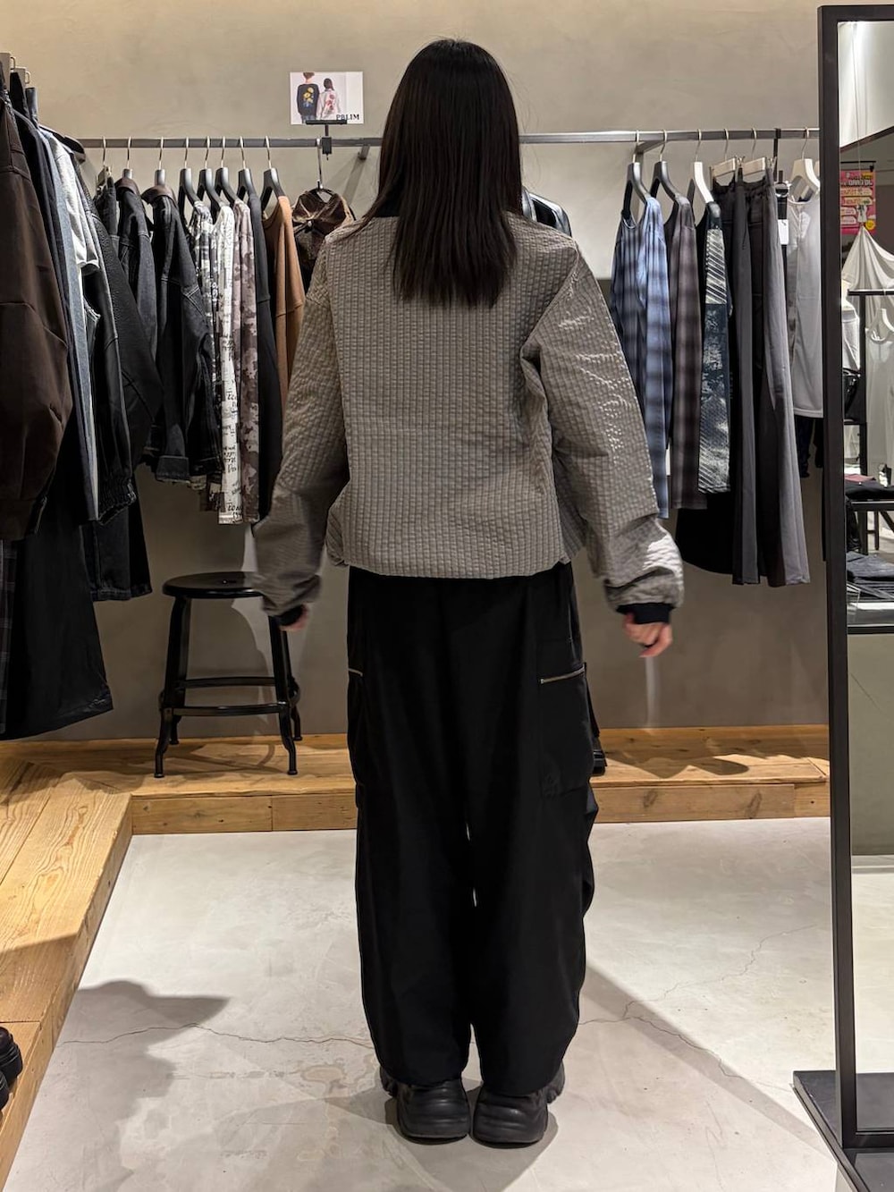 ブラック系のカーゴパンツ、グレー系のポロシャツ、ブラック系のブーツを着用したレディースの秋コーディネートの3枚目の写真