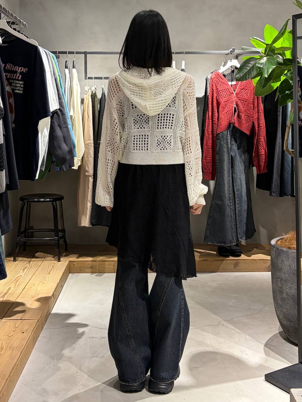 ブラック系のブーツ、ブルー系のデニムパンツ、ホワイト系のパーカーを着用したレディースの春コーディネートの3枚目の写真