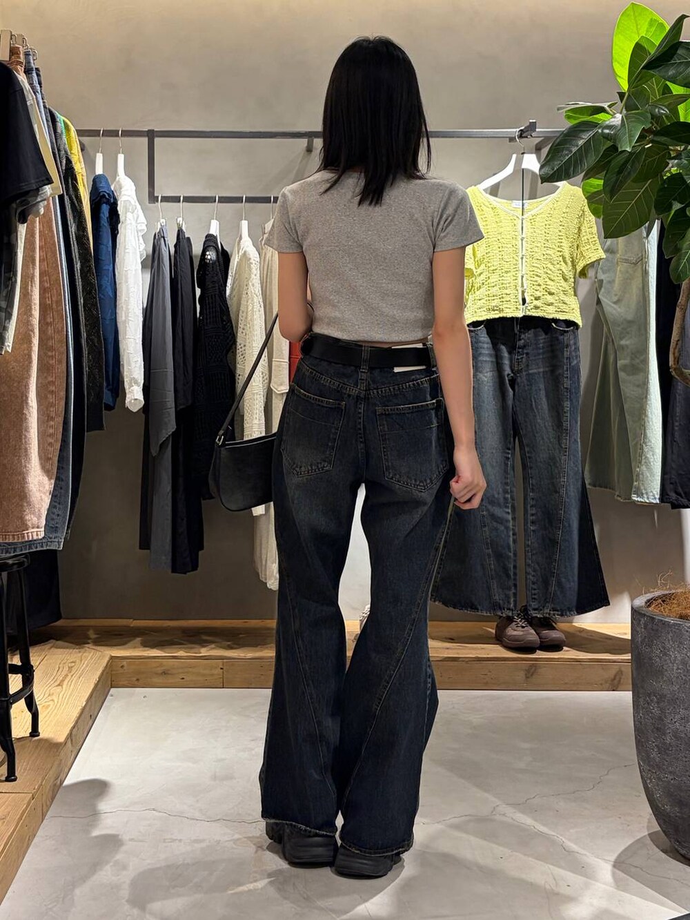 ブルー系のデニムパンツ、ブラック系のハンドバッグ、グレー系のTシャツ/カットソーを着用したレディースの春コーディネートの3枚目の写真