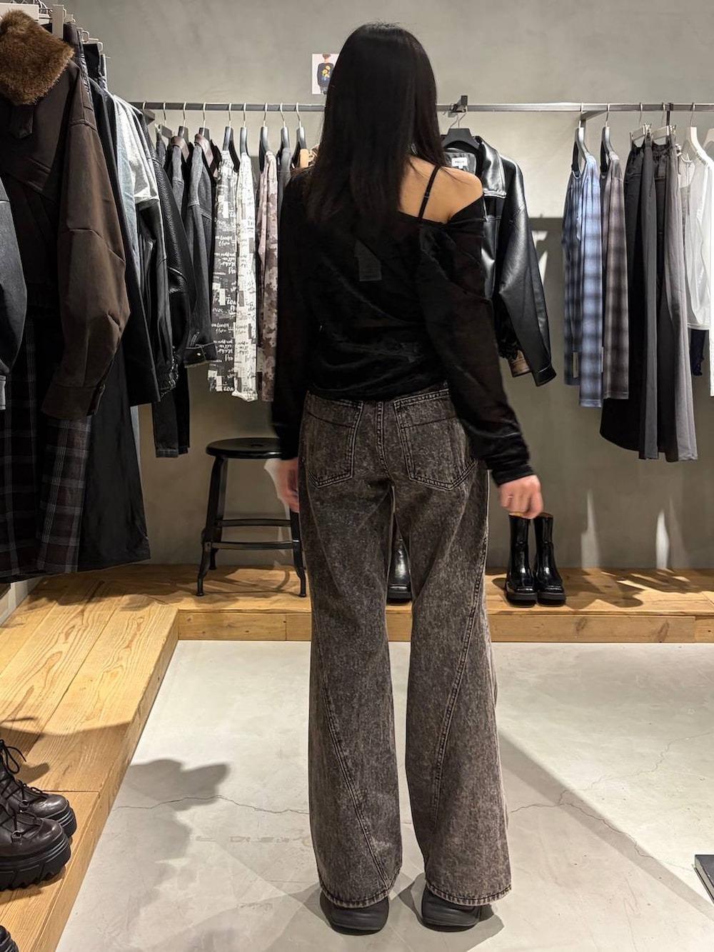ブラック系のTシャツ/カットソー、ブラック系のブーツ、ブラック系のデニムパンツを着用したレディースの秋コーディネートの3枚目の写真