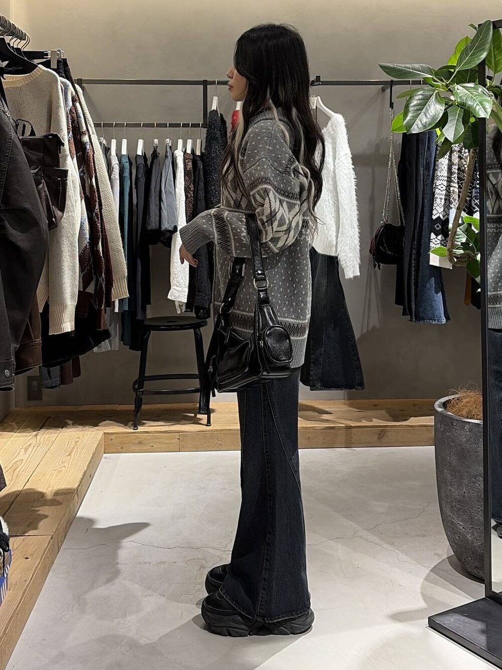 ブラック系のブーツ、ブルー系のデニムパンツ、ブラック系のショルダーバッグを着用したレディースの冬コーディネートの2枚目の写真