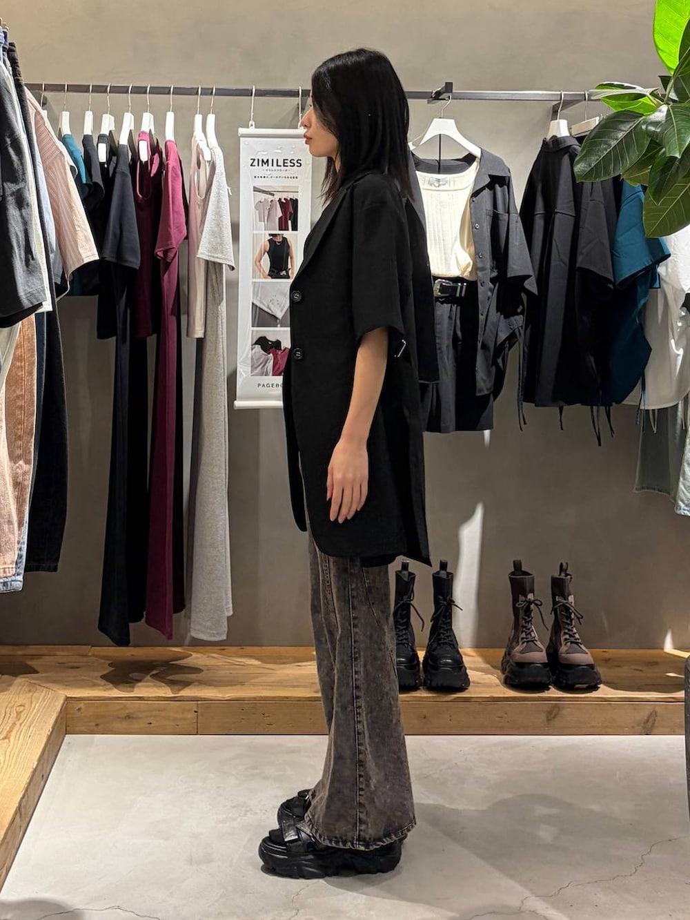 ブラック系のデニムパンツ、ブラック系のサンダル、ブラック系のテーラードジャケットを着用したレディースの春コーディネートの2枚目の写真