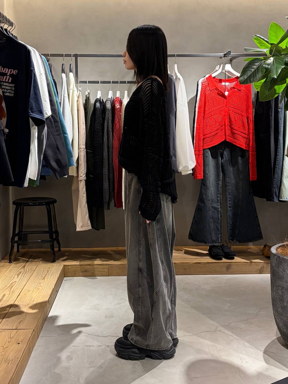 ブラック系のブーツ、ブラック系のデニムパンツ、ブラック系のニット/セーターを着用したレディースの春コーディネートの2枚目の写真