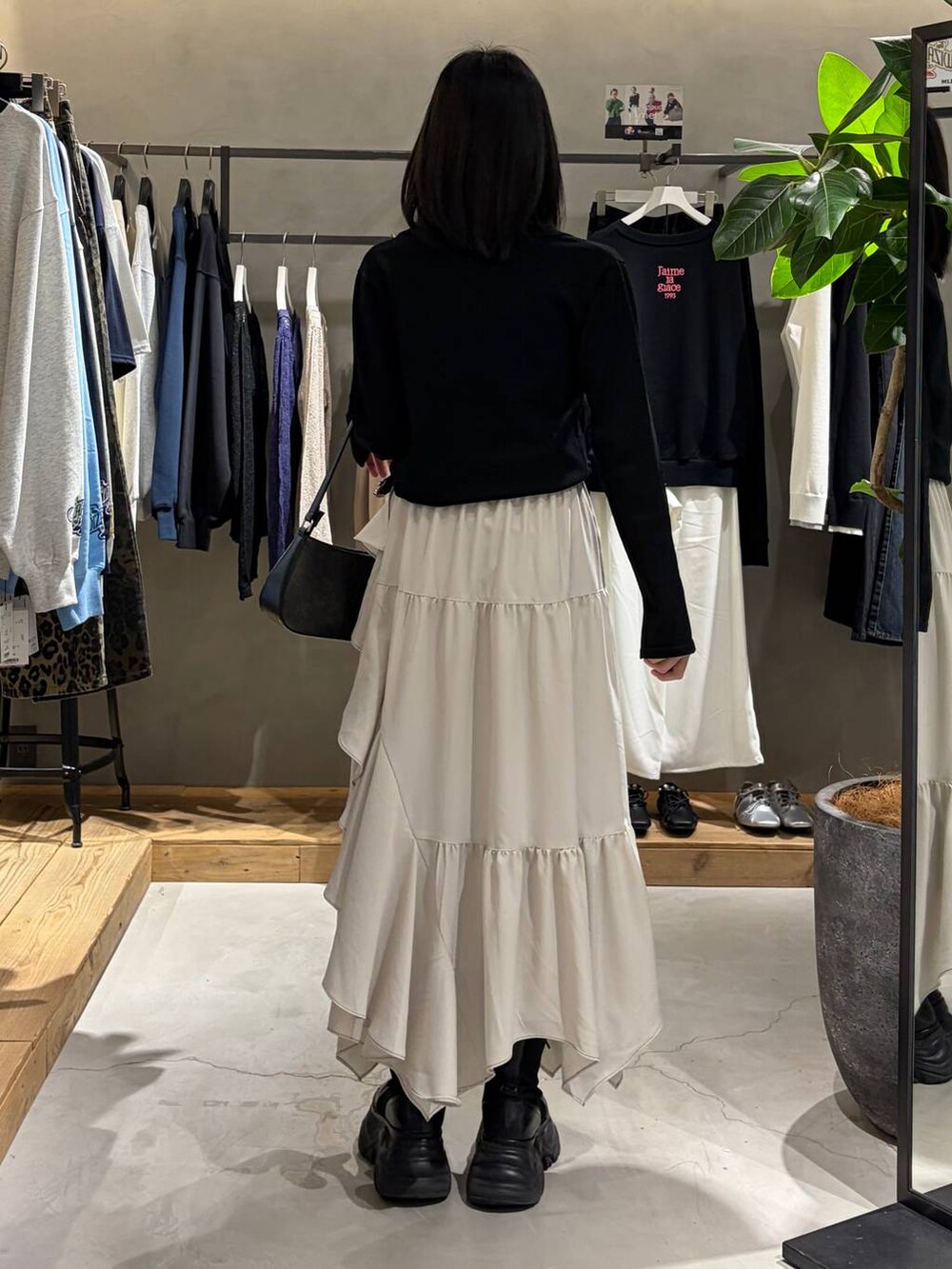 ベージュ系のスカート、ブラック系のハンドバッグ、ブラック系のカーディガン/ボレロを着用したレディースの春コーディネートの3枚目の写真