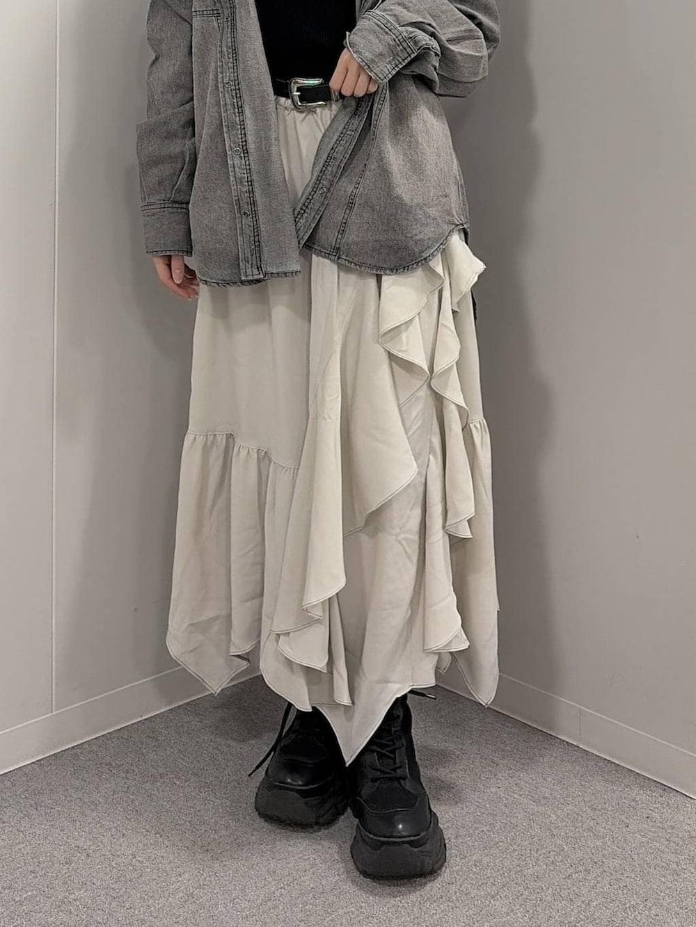 ブラック系のブーツ、ベージュ系のスカート、ブラック系のシャツ/ブラウスを着用したレディースの冬コーディネートの5枚目の写真