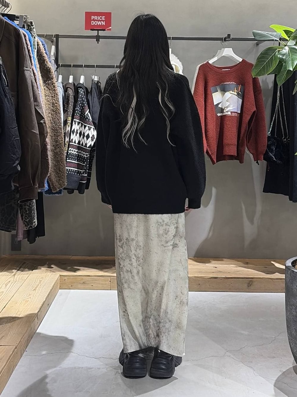 ブラック系のブーツ、ホワイト系のスカート、ブラック系のニット/セーターを着用したレディースの冬コーディネートの3枚目の写真