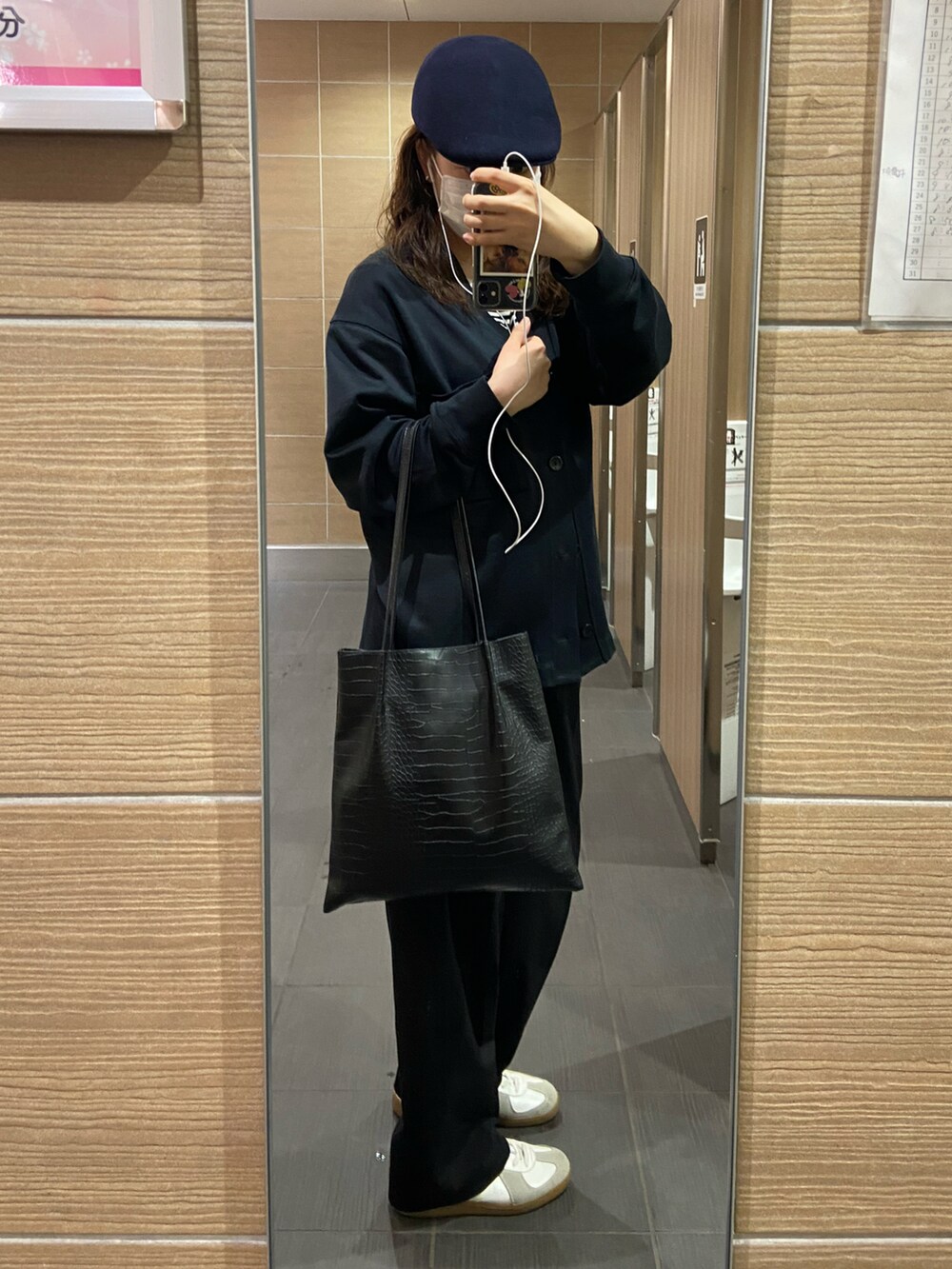 ブラック系のカーディガン/ボレロ、ブラック系のパンツ、ホワイト系のスニーカーを着用したレディースの春コーディネートの2枚目の写真