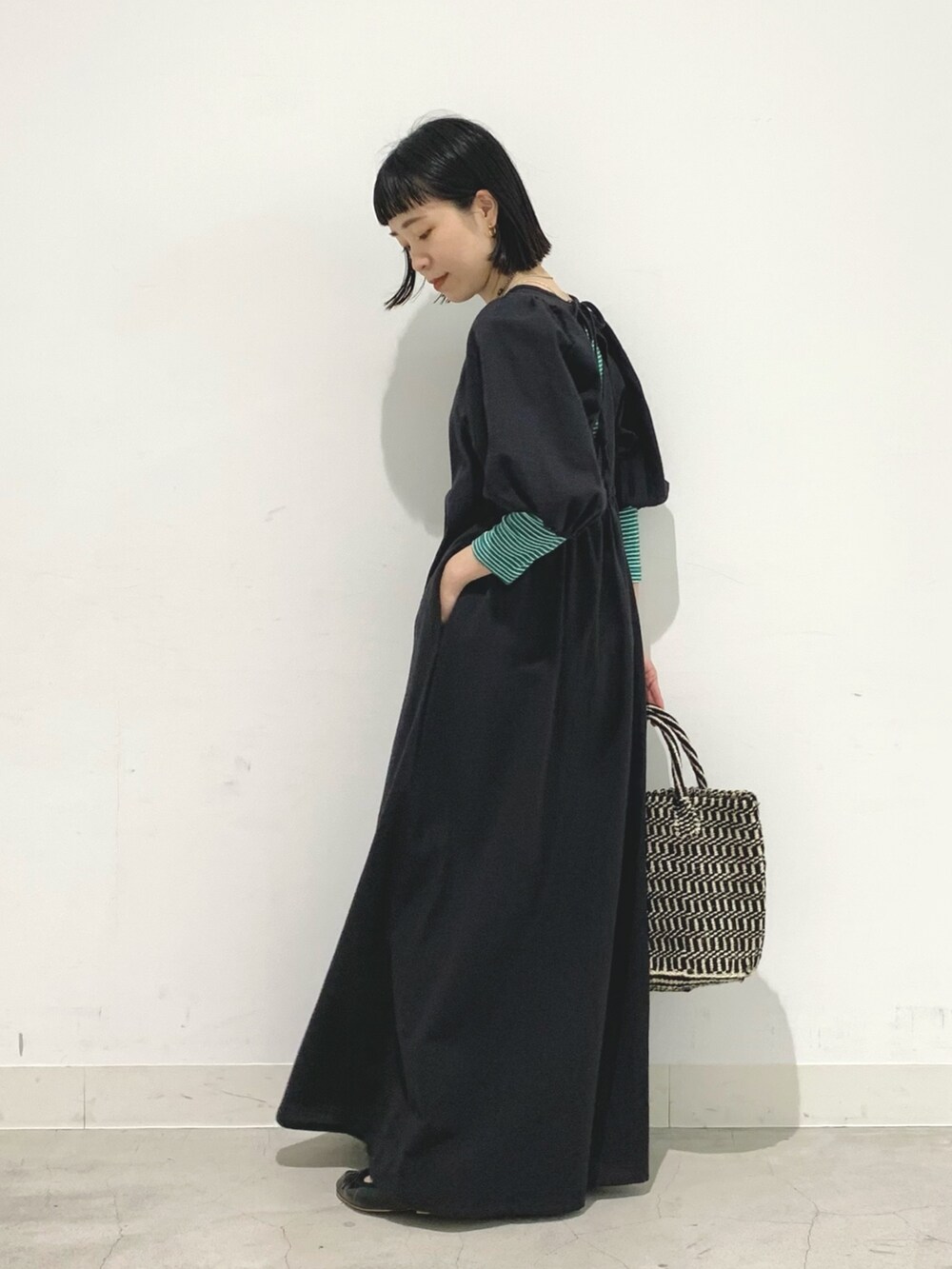 ブラック系のワンピース、ブラック系のかごバッグを着用したレディースの春コーディネートの3枚目の写真