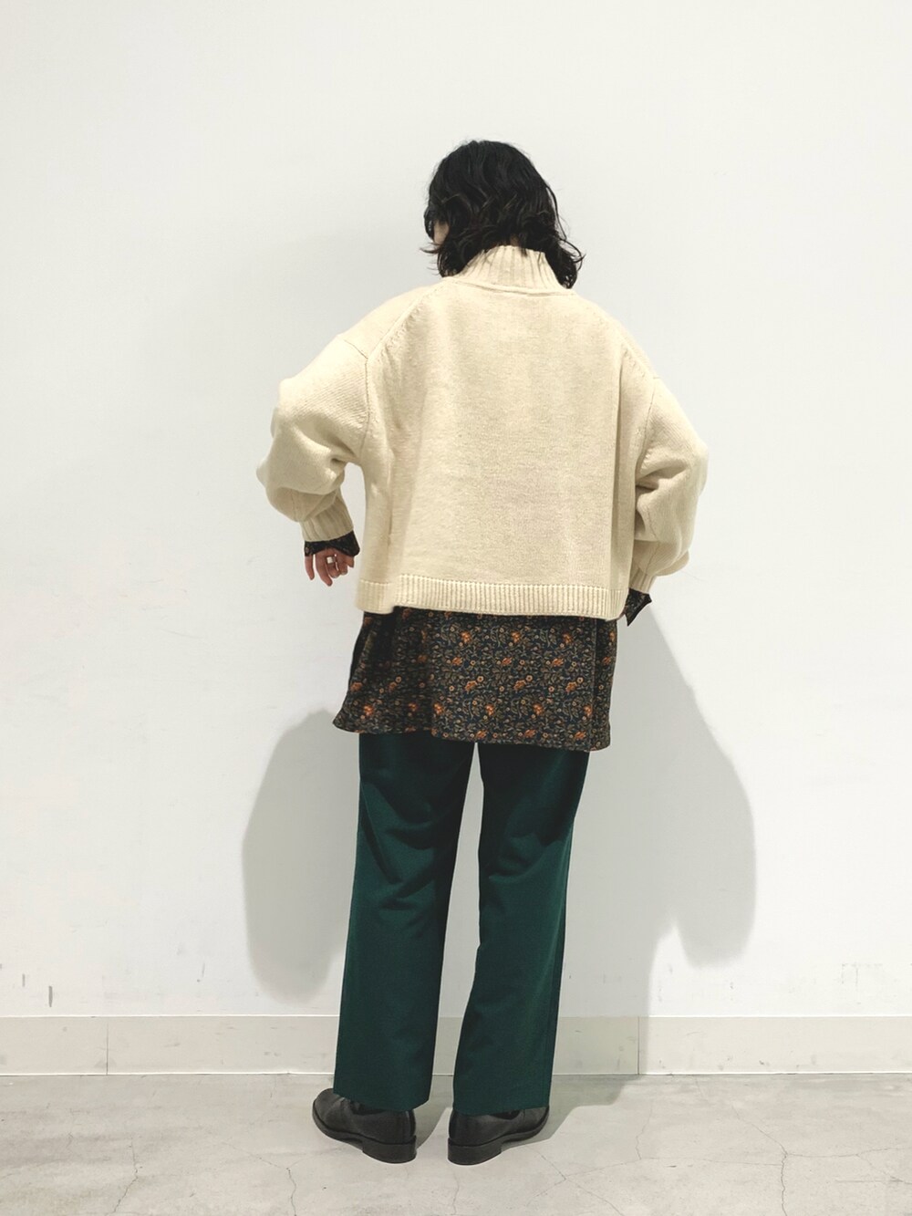 ホワイト系のニット/セーター、グリーン系のスラックス、グリーン系のシャツ/ブラウスを着用したレディースの秋コーディネートの2枚目の写真