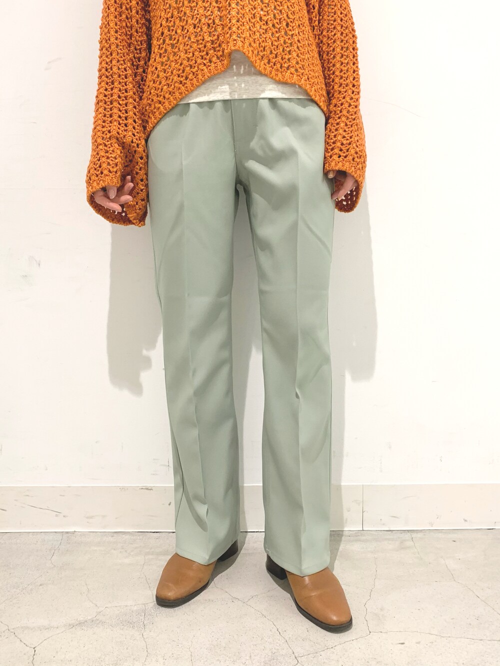 オレンジ系のニット/セーター、グレー系のTシャツ/カットソーを着用したレディースの冬コーディネートの4枚目の写真