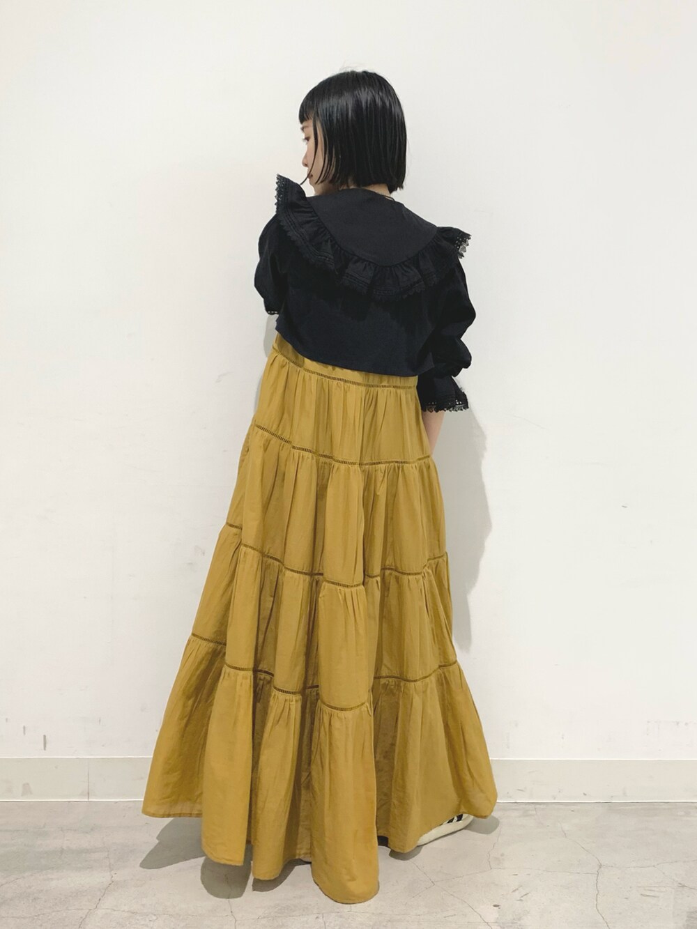 ベージュ系のワンピース、ブラック系のシャツ/ブラウスを着用したレディースの春コーディネートの2枚目の写真