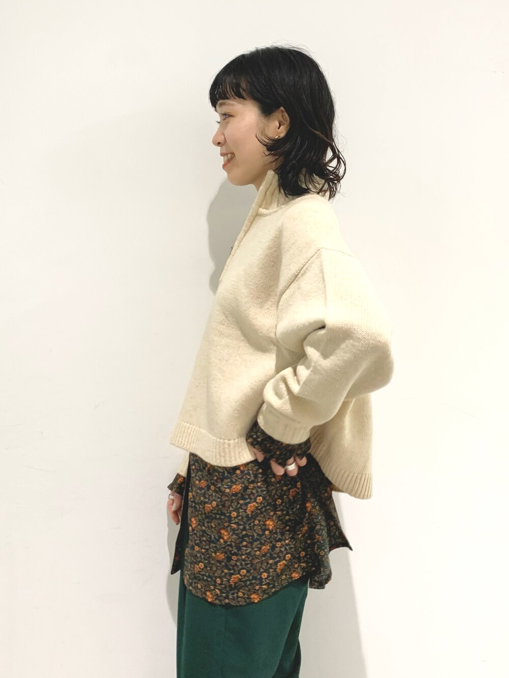 ホワイト系のニット/セーター、グリーン系のスラックス、グリーン系のシャツ/ブラウスを着用したレディースの秋コーディネートの4枚目の写真