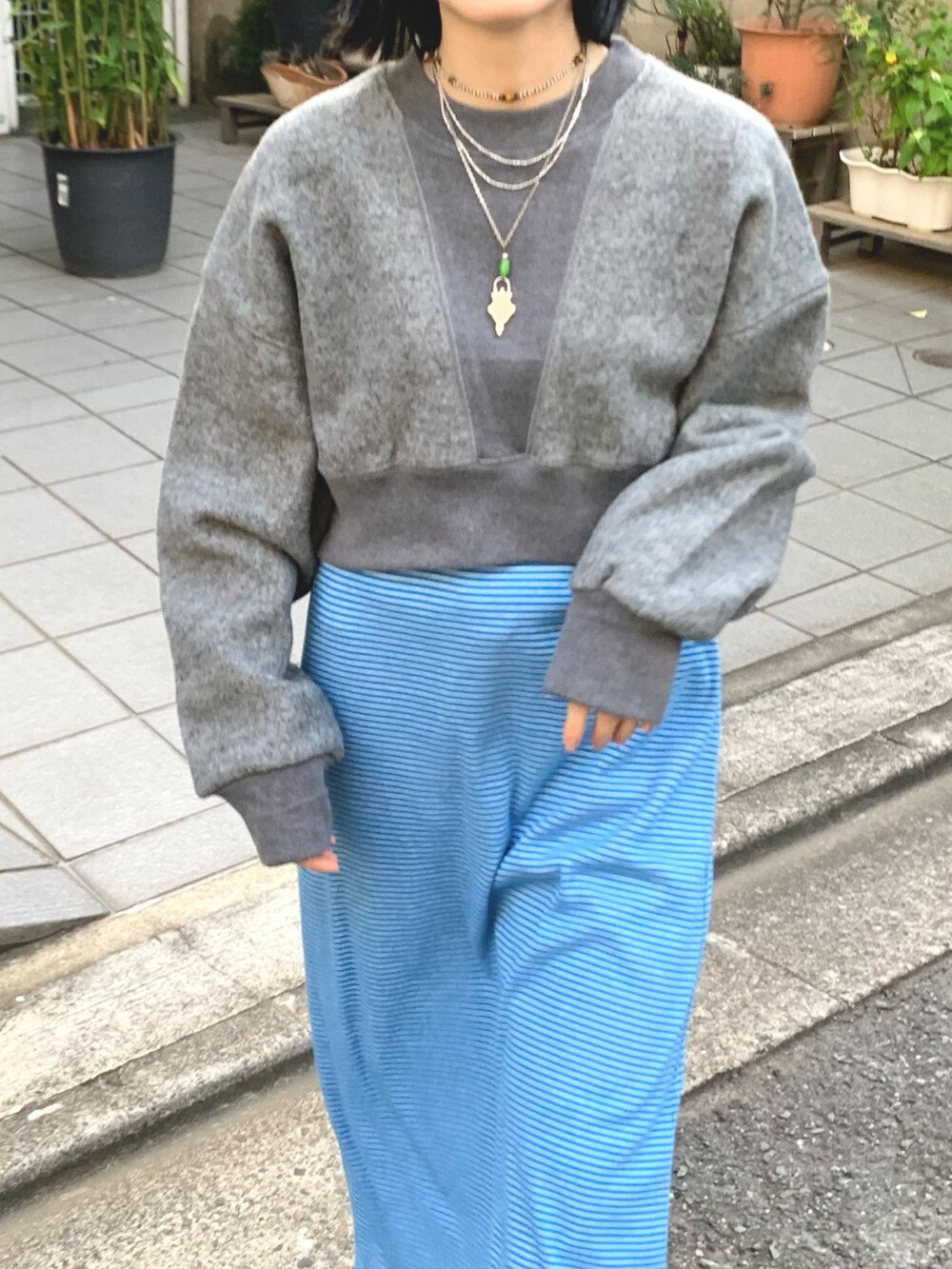 ブルー系のワンピース、ブルー系のデニムパンツ、グレー系のスウェットを着用したレディースの秋コーディネートの3枚目の写真