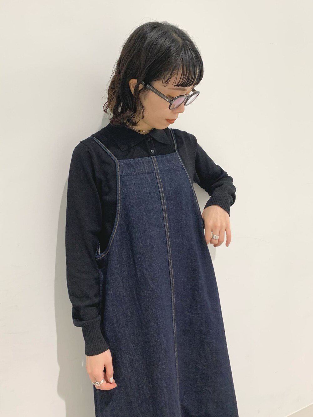 ブルー系のワンピース、ブラック系のポロシャツを着用したレディースの秋コーディネートの4枚目の写真