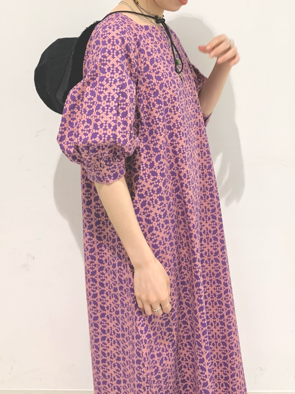 パープル系のワンピース、ブラック系のサンダル、ブラック系のハットを着用したレディースの夏コーディネートの4枚目の写真