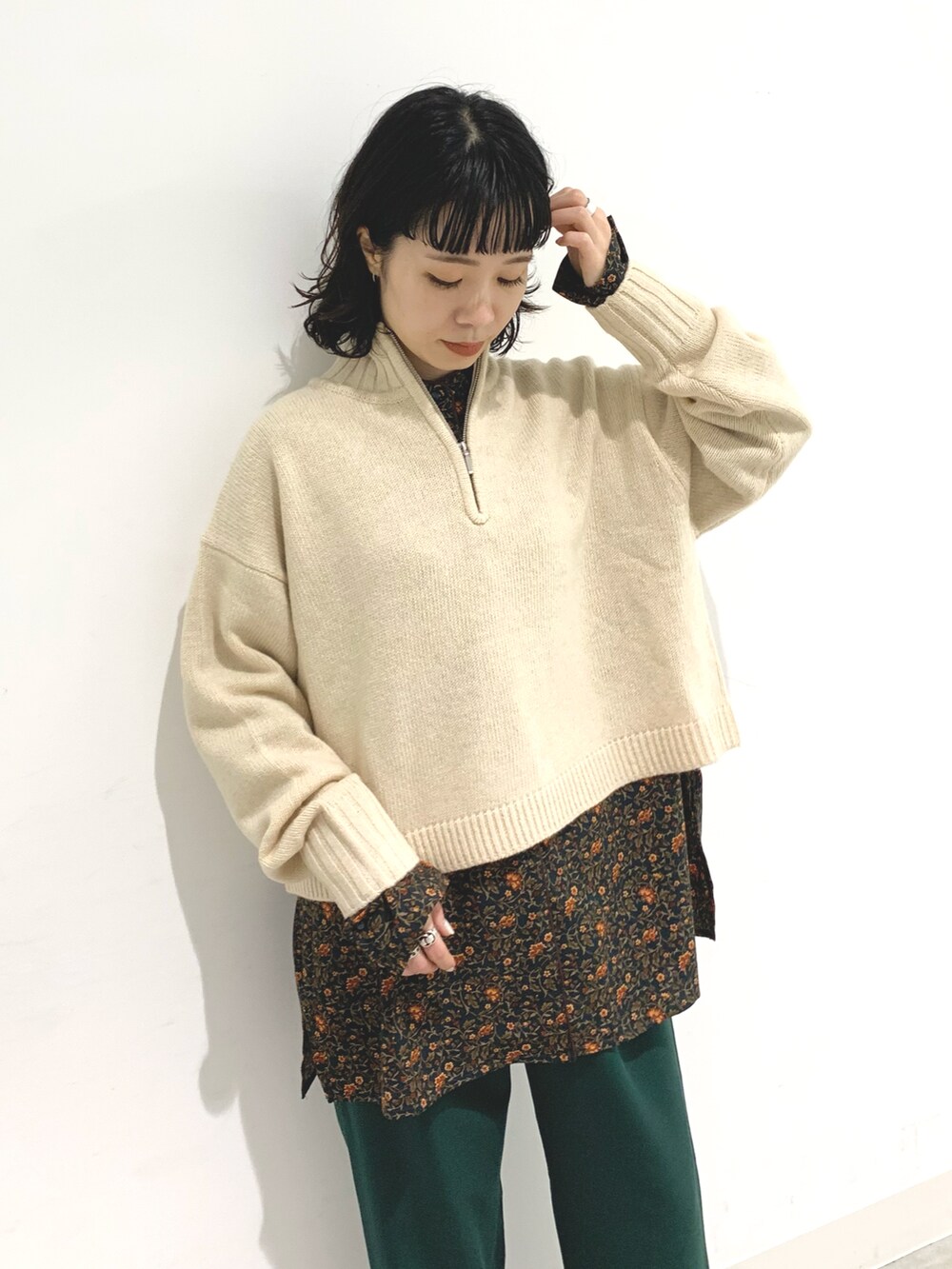 ホワイト系のニット/セーター、グリーン系のスラックス、グリーン系のシャツ/ブラウスを着用したレディースの秋コーディネートの3枚目の写真