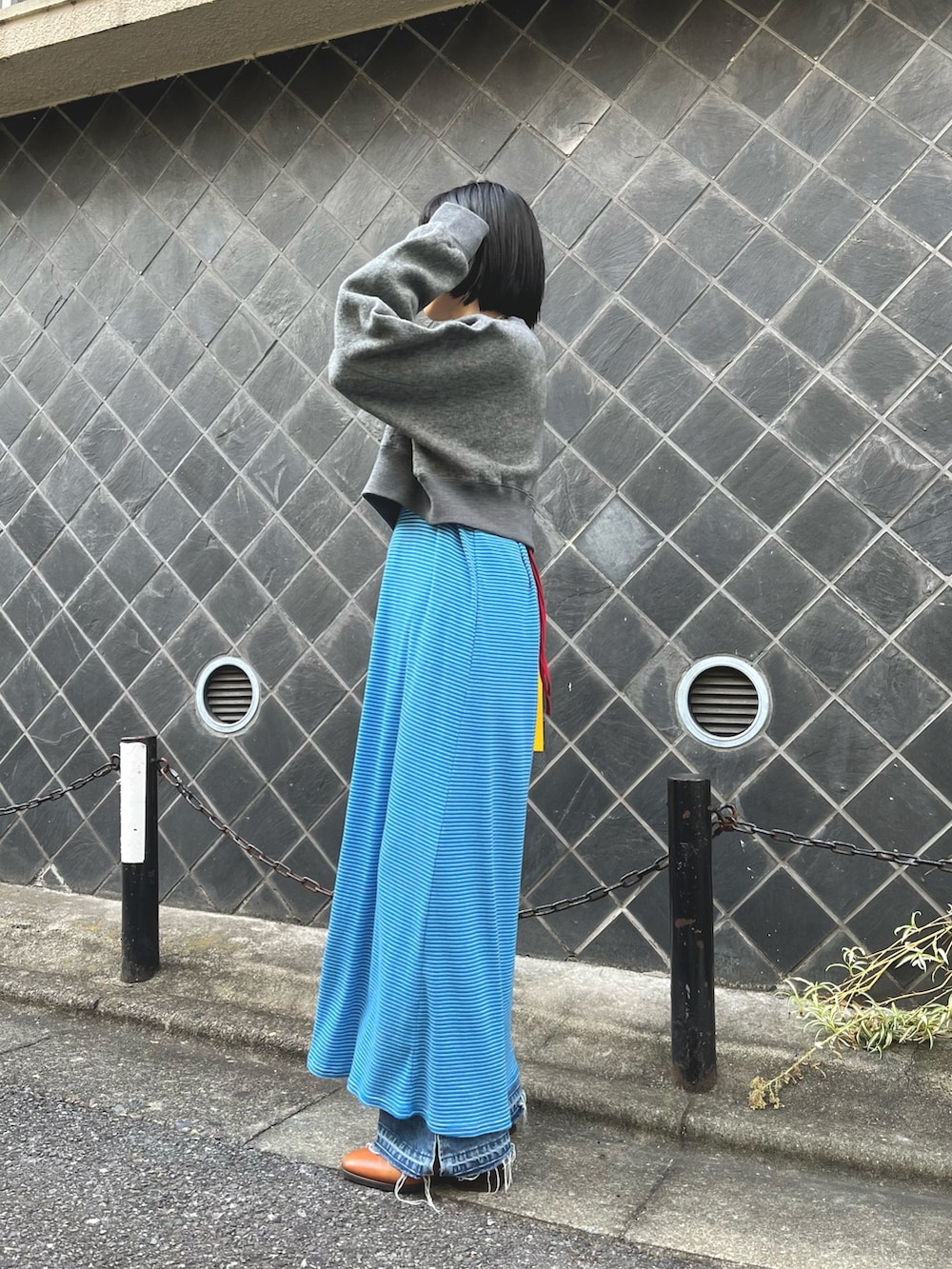 ブルー系のワンピース、ブルー系のデニムパンツ、グレー系のスウェットを着用したレディースの秋コーディネートの2枚目の写真