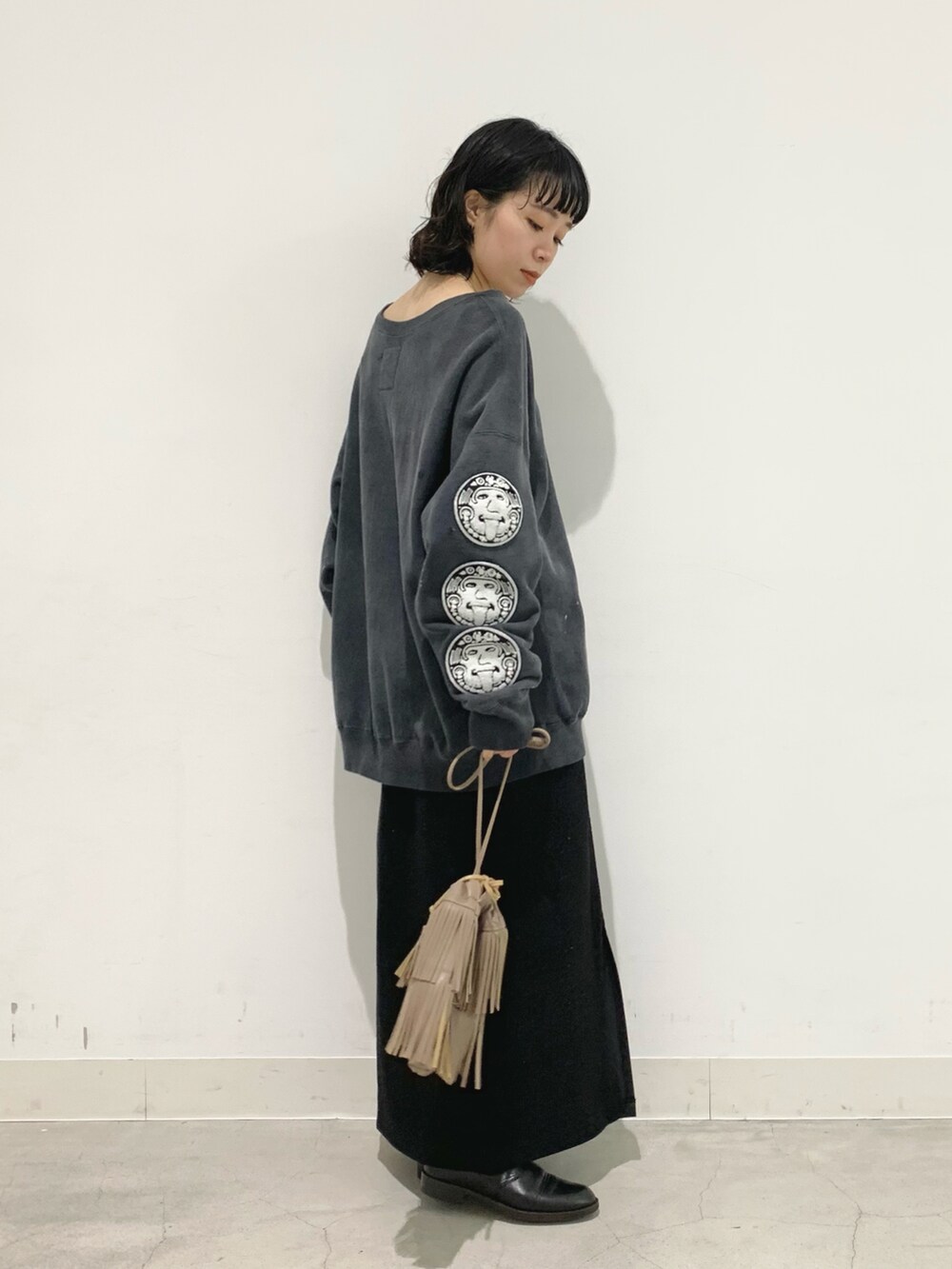 グレー系のショルダーバッグ、ブラック系のスカート、ブラック系のスウェットを着用したレディースの秋コーディネートの2枚目の写真