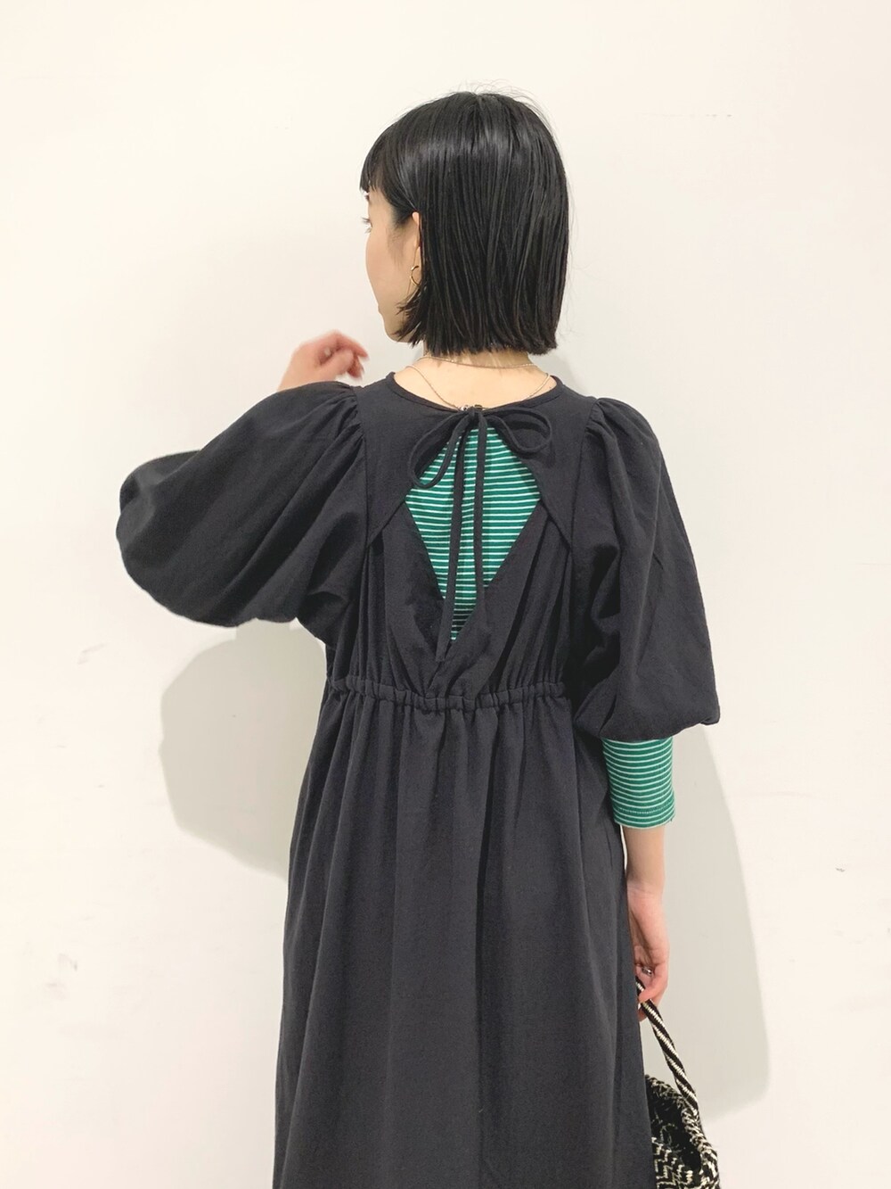 ブラック系のワンピース、ブラック系のかごバッグを着用したレディースの春コーディネートの5枚目の写真