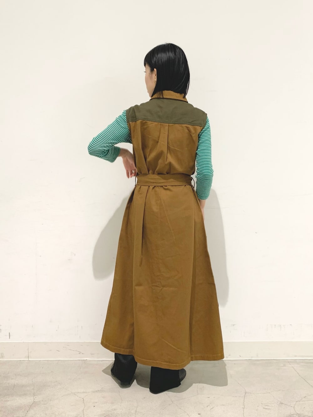 ブラウン系のベスト、ブラック系のパンツ、パープル系のショルダーバッグを着用したレディースの秋コーディネートの2枚目の写真