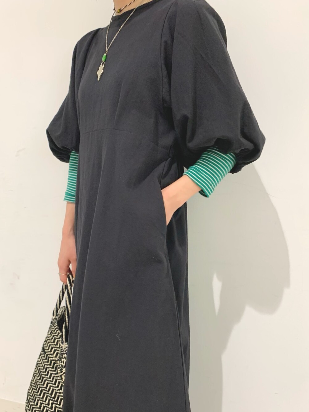 ブラック系のワンピース、ブラック系のかごバッグを着用したレディースの春コーディネートの4枚目の写真