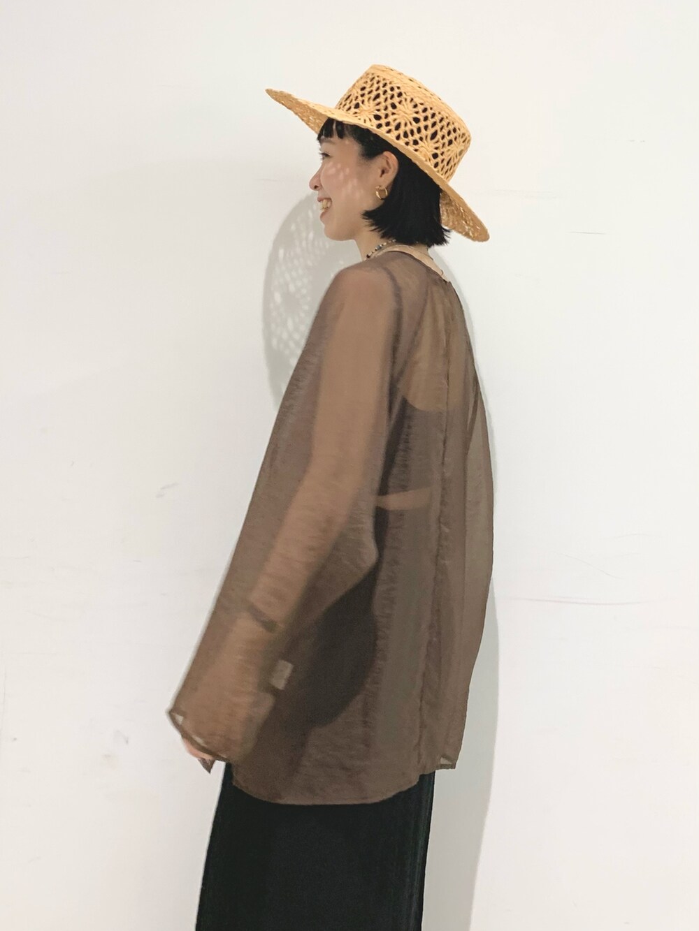 ブラック系のスカート、ブラウン系のシャツ/ブラウスを着用したレディースの夏コーディネートの2枚目の写真