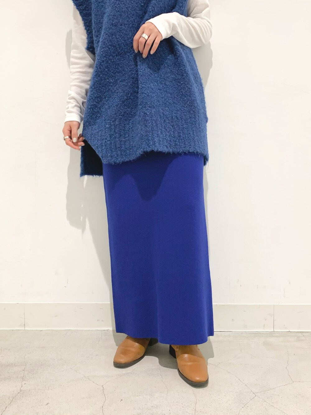 ブルー系のベスト、ブルー系のスカート、ホワイト系のTシャツ/カットソーを着用したレディースの秋コーディネートの4枚目の写真